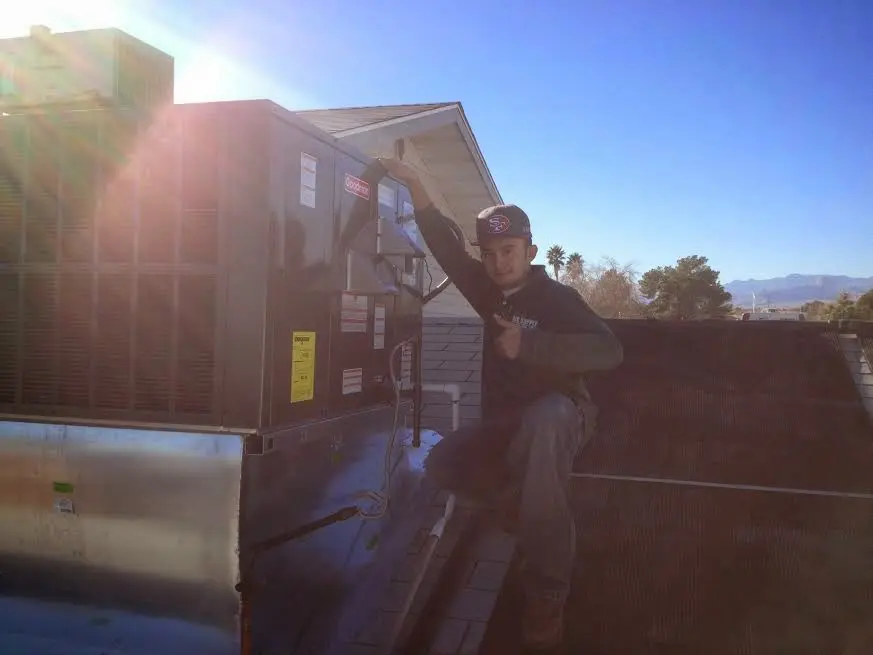 HVAC technician performing AC Tune-Up on a rooftop unit in Santa Fe